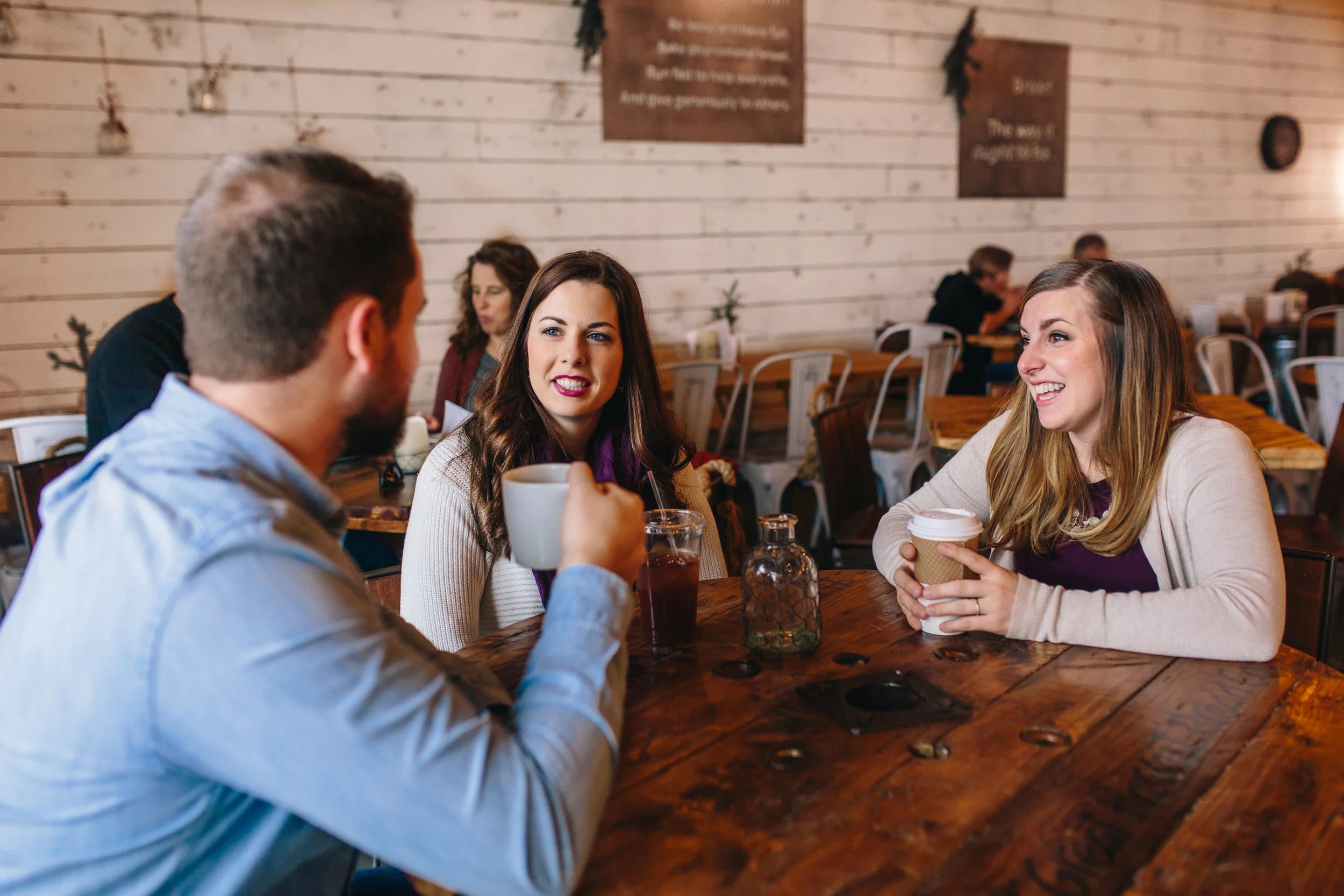 A doula in conversation with expectant parents at a coffee shop